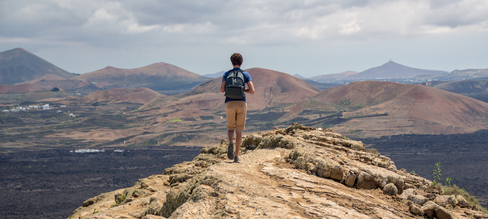 A tourist walking along the Caldera Blanca trail in Lanzarote, Canary Islands A tourist walking along the Caldera Blanca trail in Lanzarote, Canary Islands