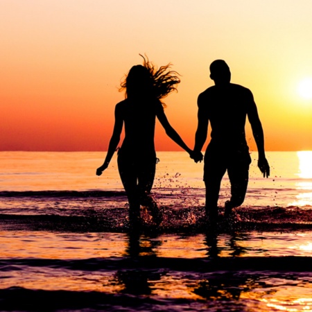 Пара наслаждается закатом на пляже