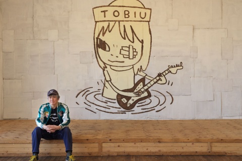 Yoshitomo Nara seduto davanti a TOBIU, 2019. Donazione dell