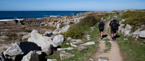 Two pilgrims walking along the coast in A Guarda